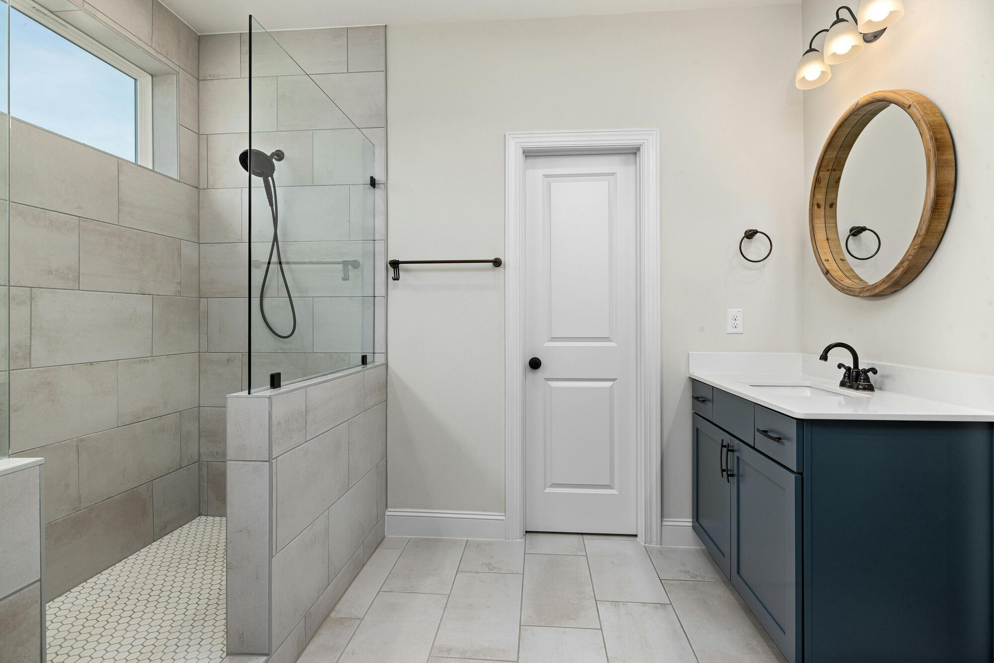 Tiled walk-in shower and navy vanity in a Metzler Construction custom bathroom in Perkasie, PA - Stock Image