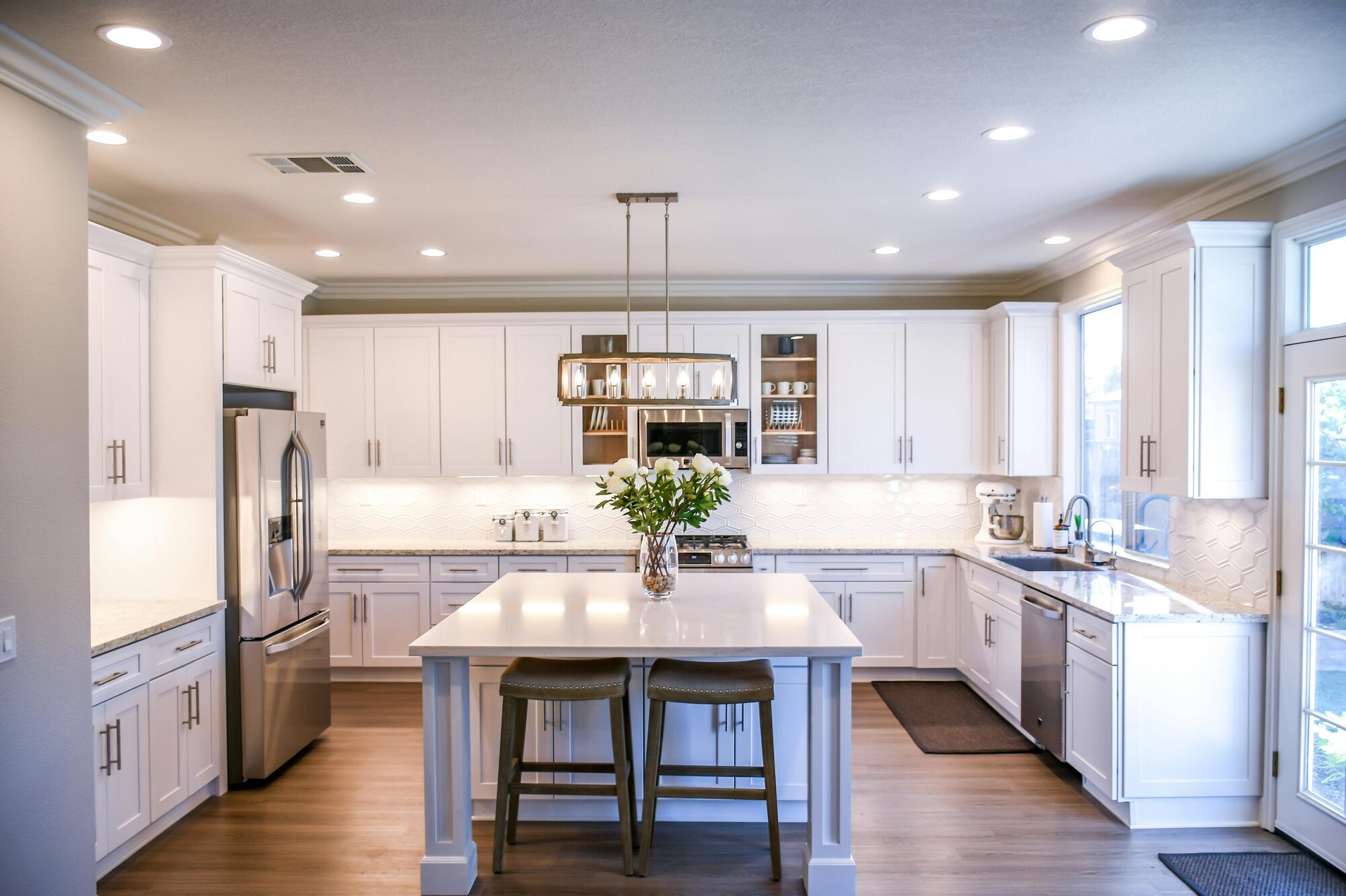 White shaker cabinet kitchen with island seating in Perkasie custom home by Metzler Construction - Stock Image