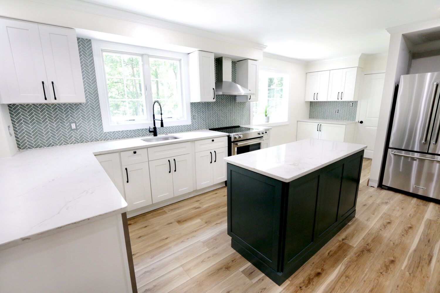 Bright white kitchen with island and herringbone backsplash in custom home by Metzler Construction in Perkasie, PA