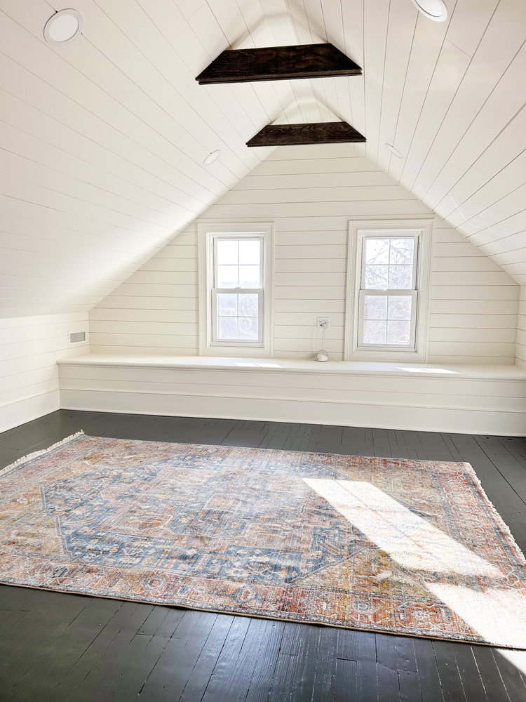 Finished attic room with white shiplap walls and patterned rug by Metzler Construction in Perkasie, PA