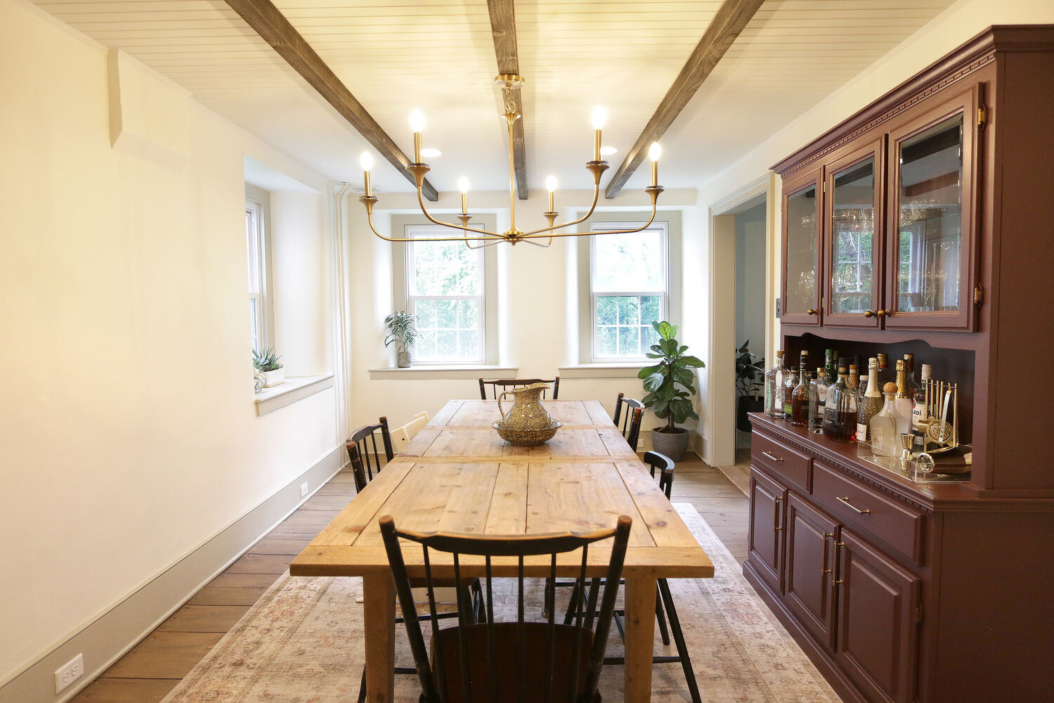 Rustic custom dining room with wood table and chandelier lighting by Metzler Construction in Perkasie, PA