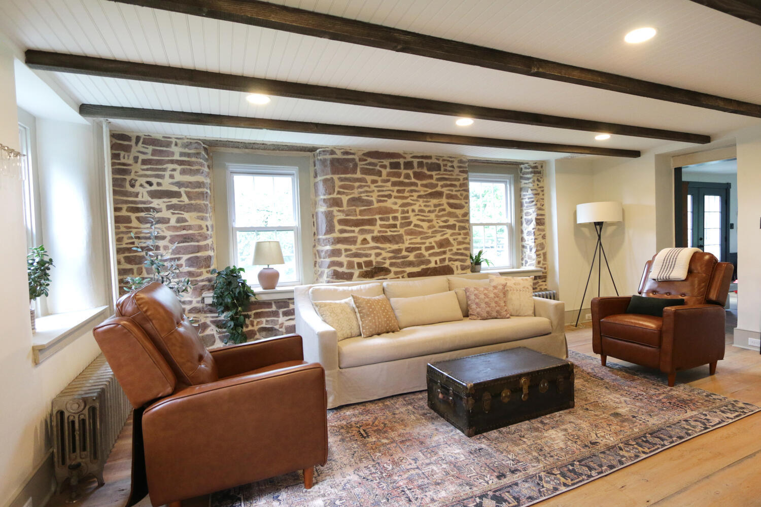 Rustic living space featuring exposed stonework and beam ceiling in a custom home by Metzler Construction in Perkasie, PA