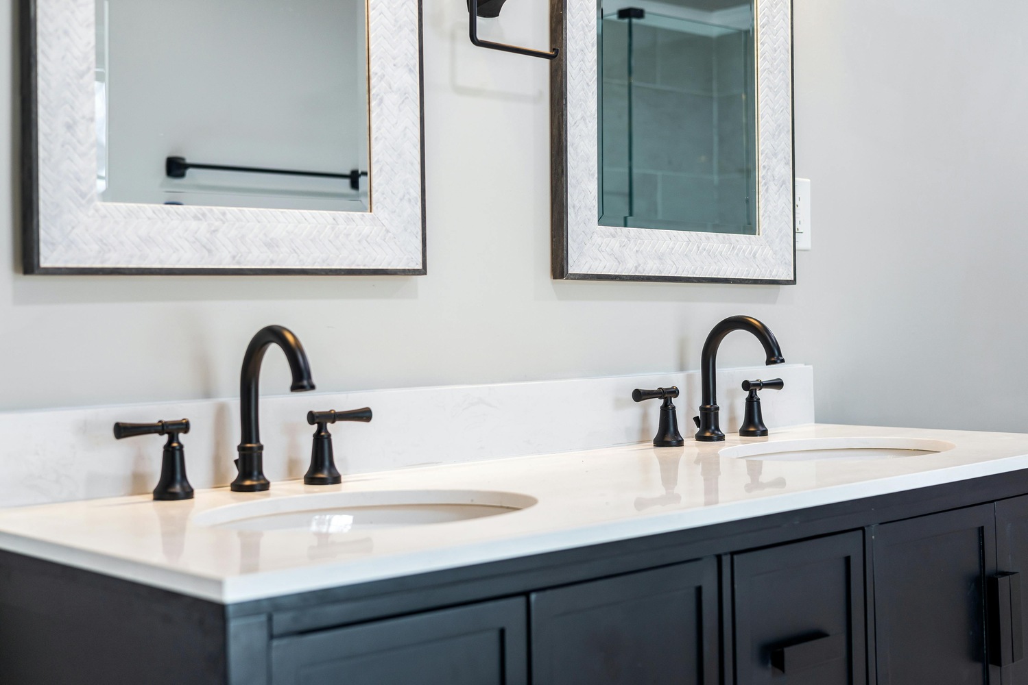 Black double vanity with white countertop in a modern custom bathroom by Metzler Construction in Perkasie, PA - Stock Image