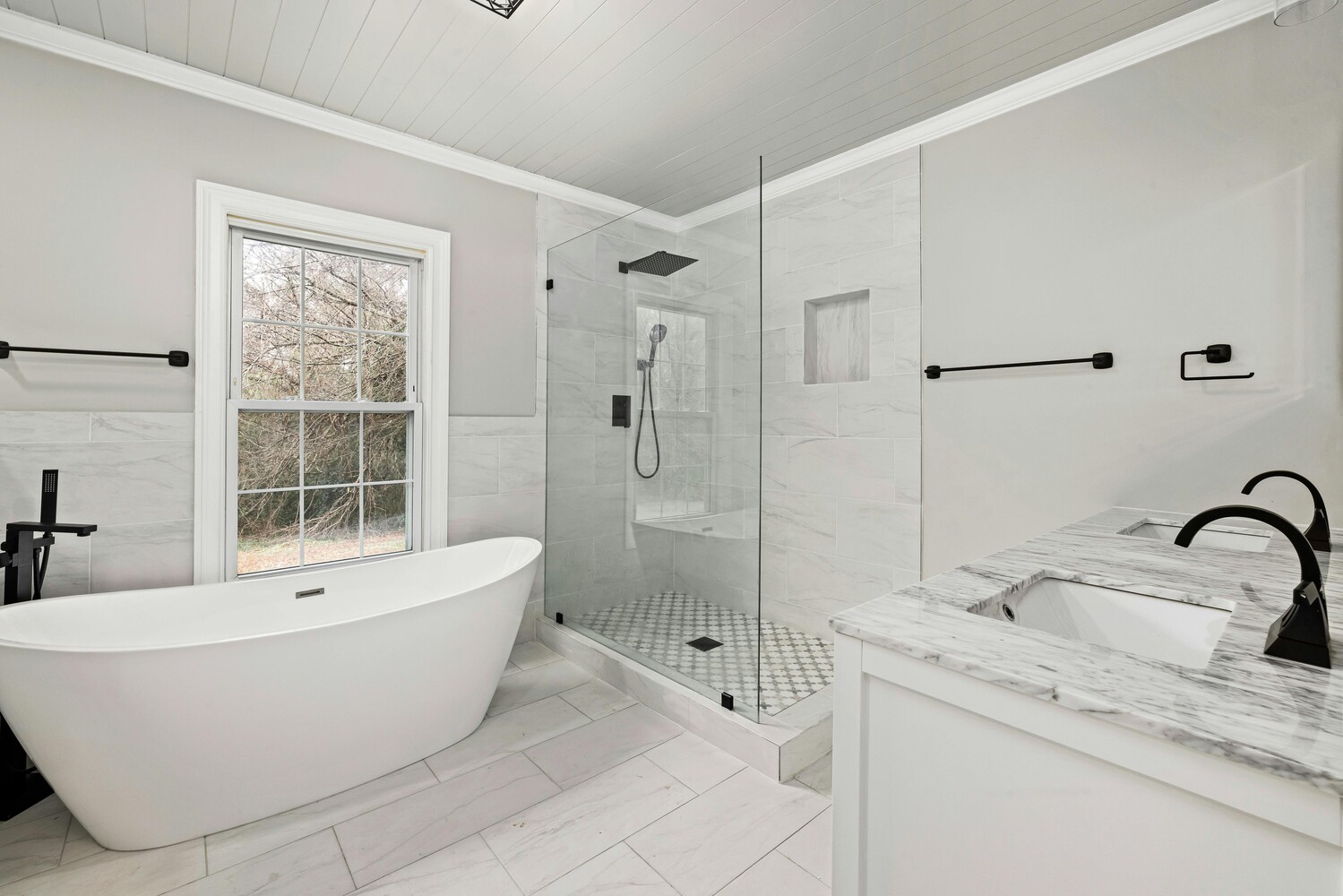 Clean and modern bath design with natural light and marble tile by Metzler Construction in Perkasie, PA - Stock Image