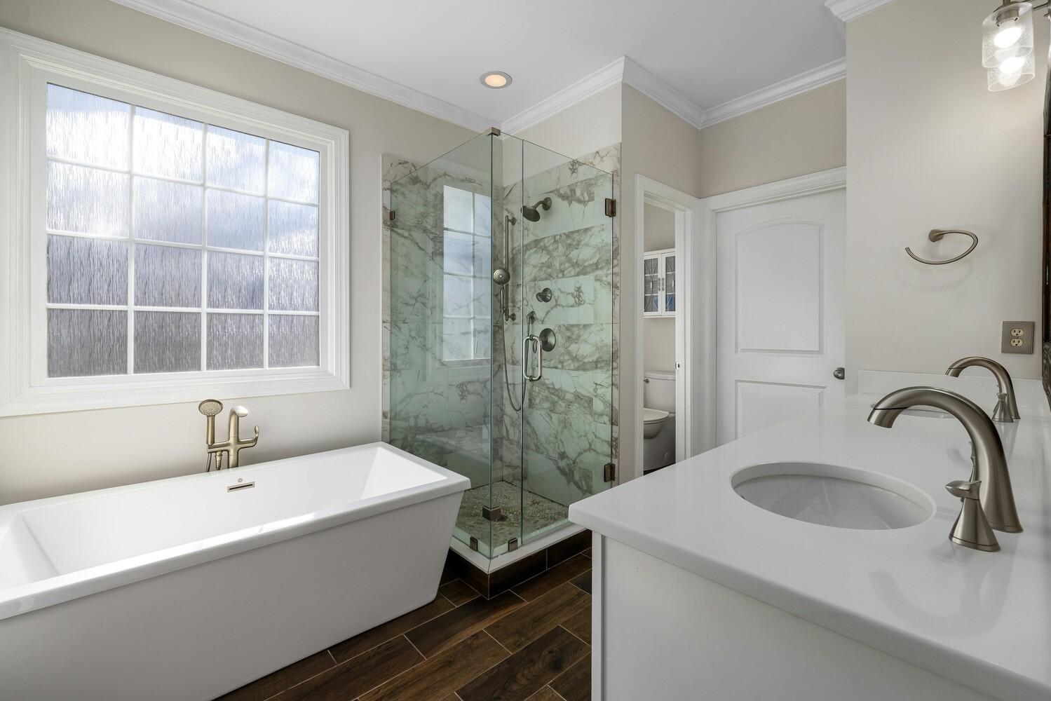 Freestanding bathtub and tiled walk-in shower in a custom Perkasie, PA home by Metzler Construction - Stock Image