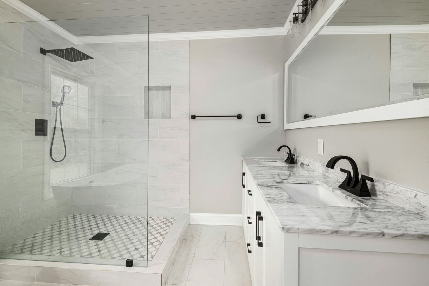 Walk-in glass shower and marble-top vanity in a custom bathroom by Metzler Construction in Perkasie, PA - Stock Image