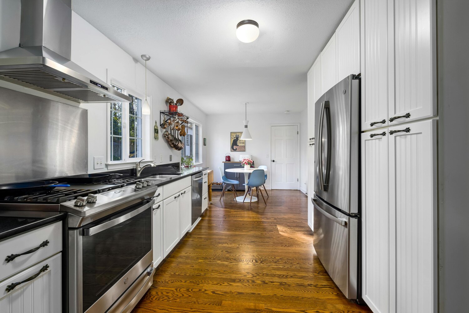 Galley-style kitchen with wood floors in custom Perkasie, PA home by Metzler Construction - Stock Image